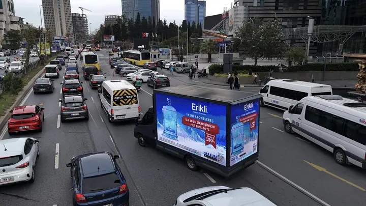Kalabalık caddede Erikli reklamı yayınlayan LED kamyon